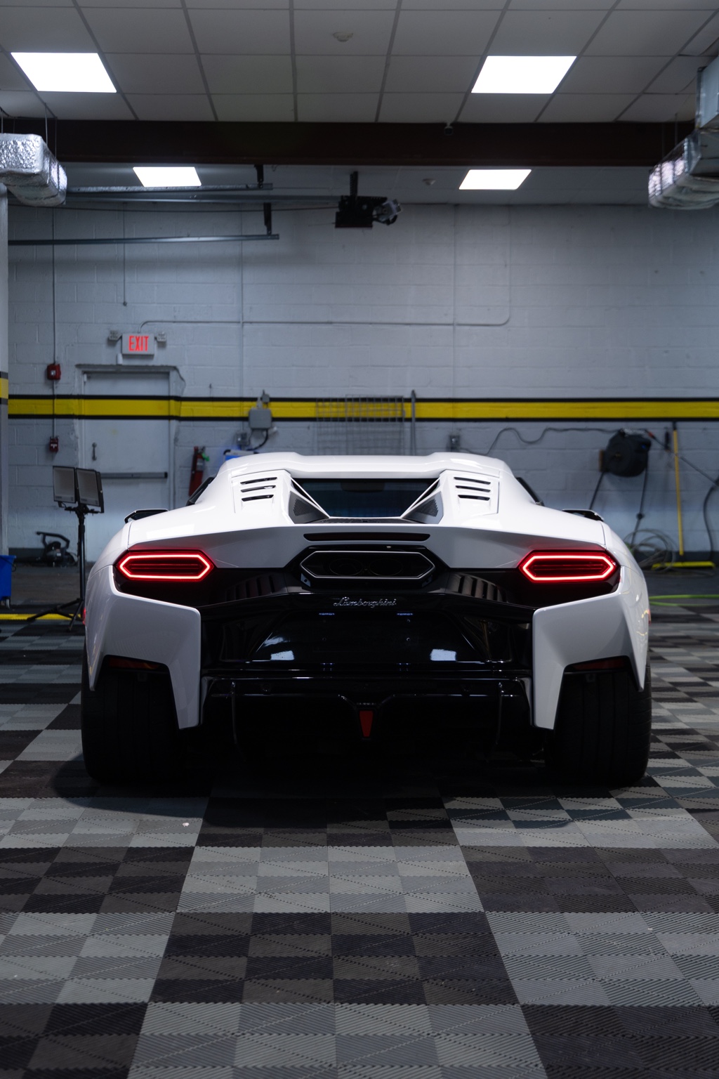 Straight rear view of a white Lamborghini Temerario in a professional automotive bay